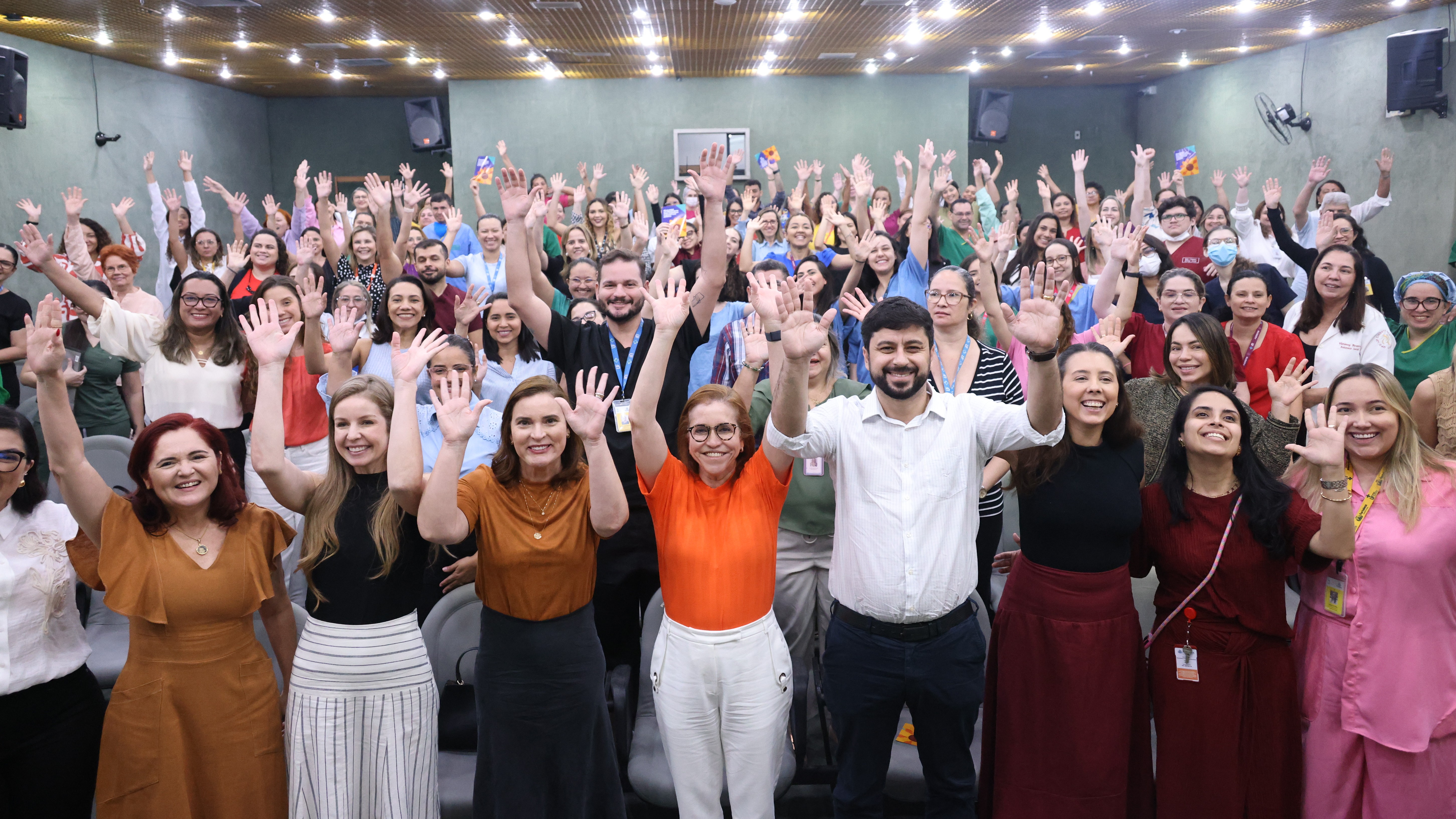 grupo de pessoas posa para a foto no auditório do IJF